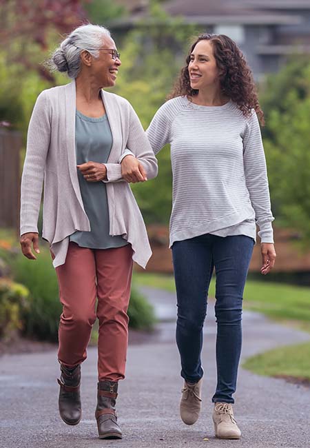 Two women walking arm in arm