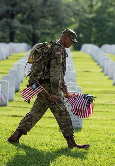 Service member placing flags on Memorial Day
