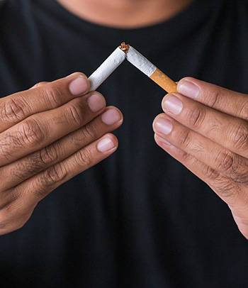 Hands breaking cigarette in half