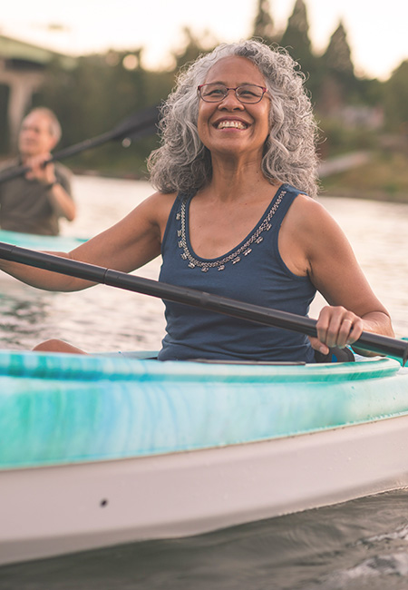 Senior woman smiles while kayaking