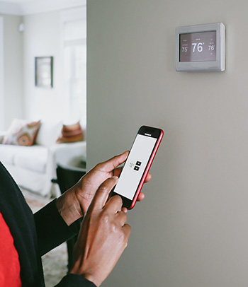 Woman changes thermostat from smart phone