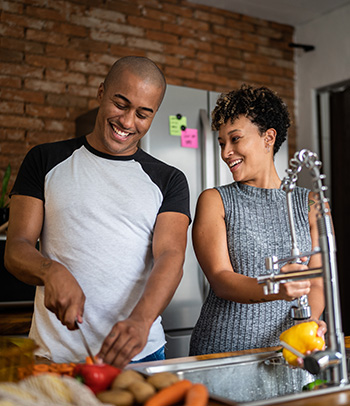 Couple washing and chopping vegetables