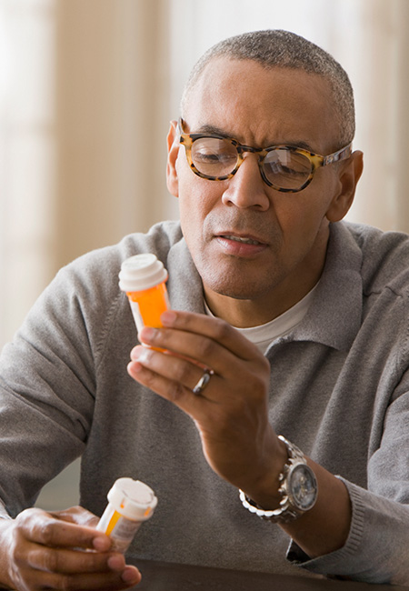 Man examining prescription bottles