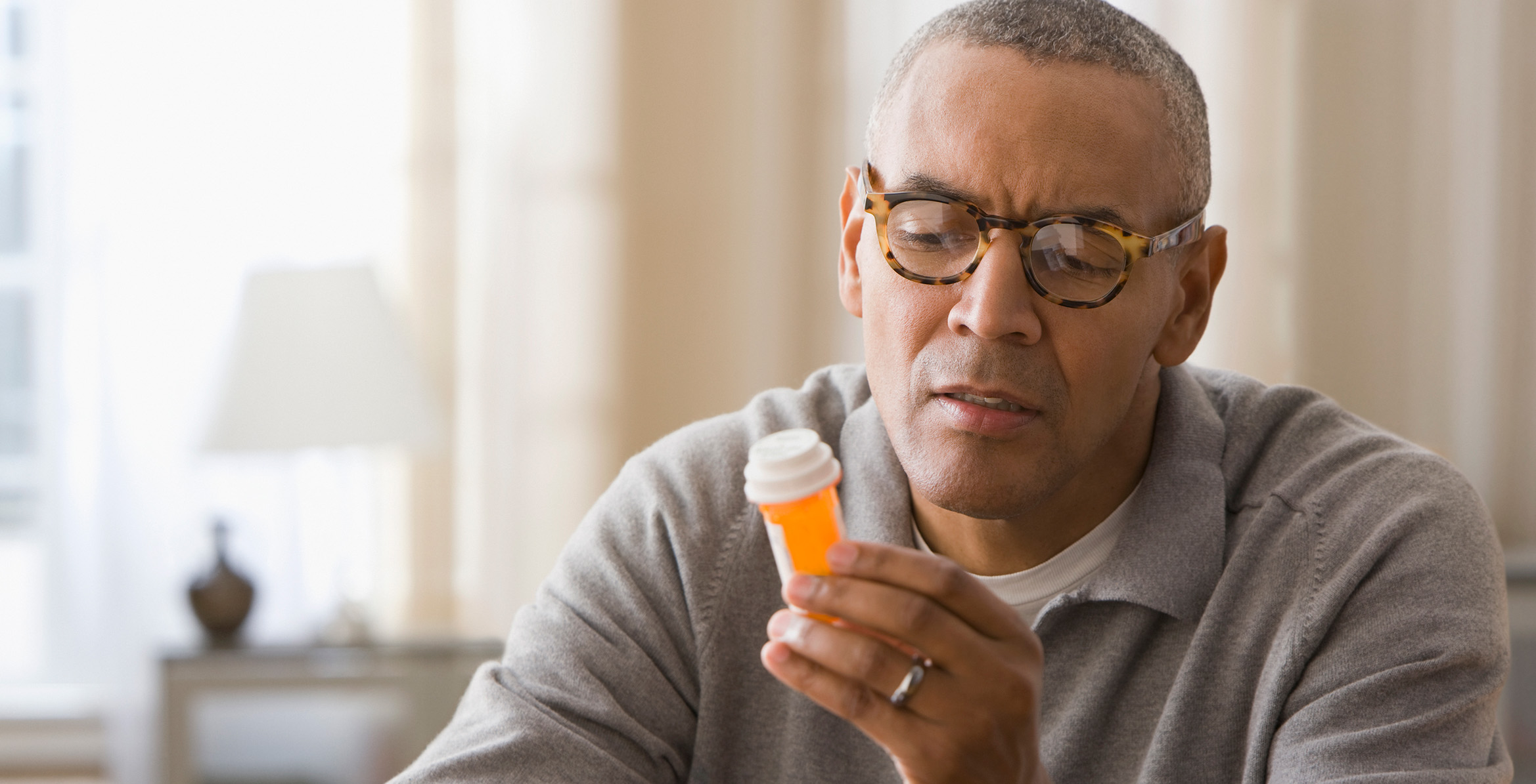 Man examining prescription bottles