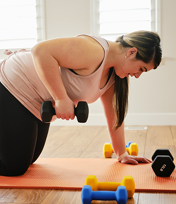 Woman using exercise weights in home
