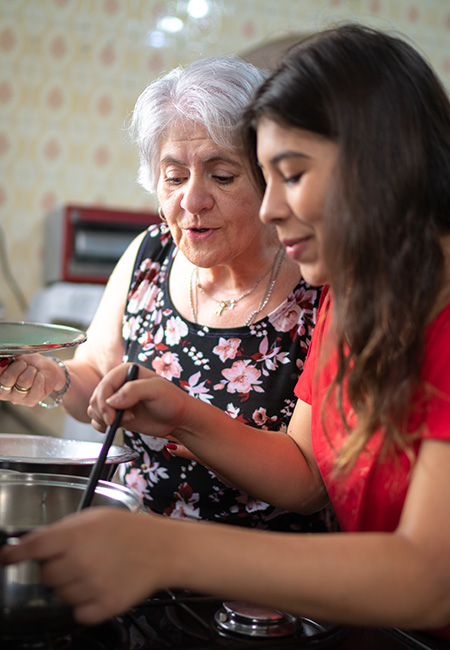 Grandmother teaching her granddaughter how to cook