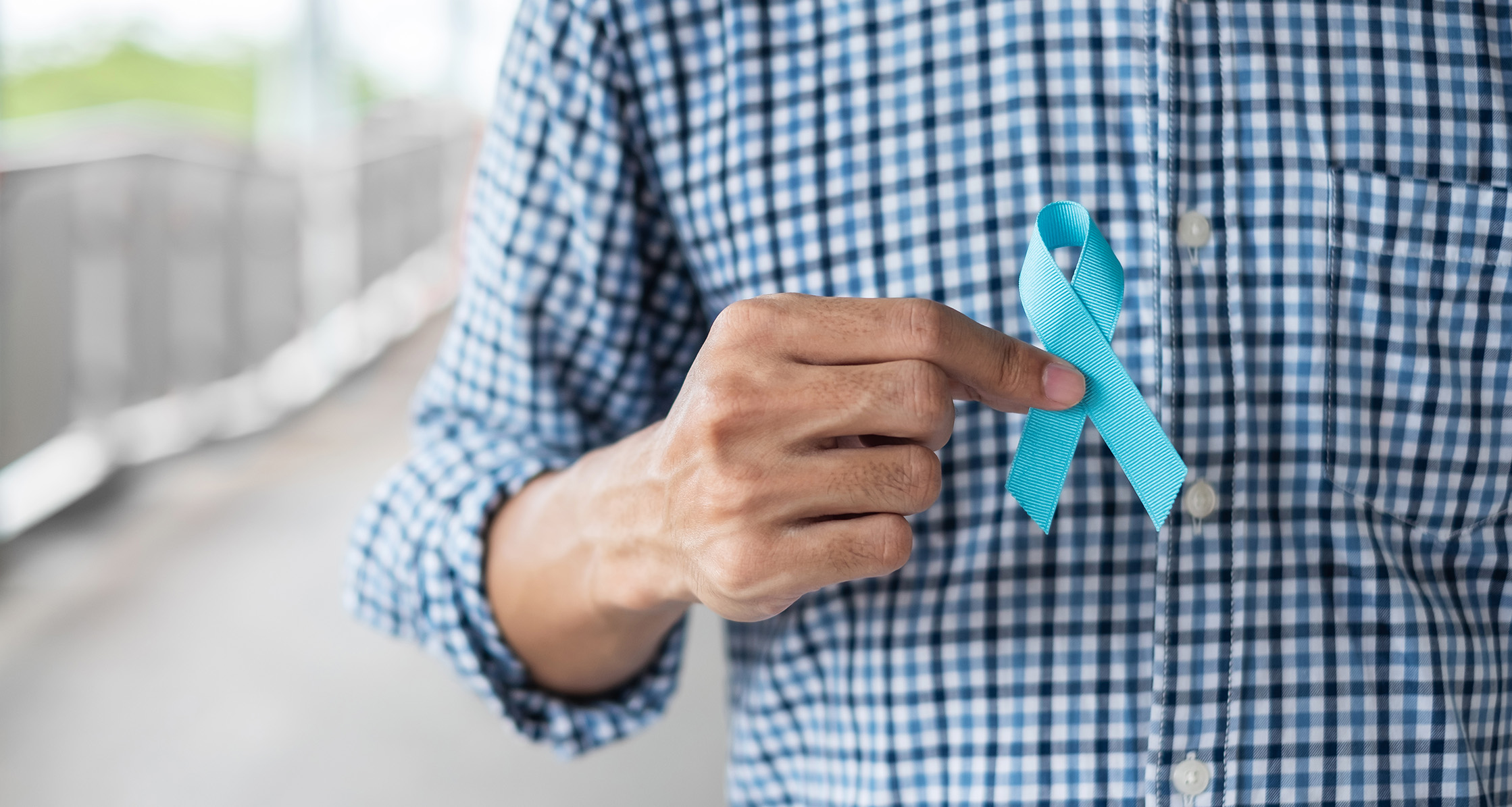 Man holding blue ribbon