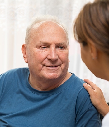 Nurse talking to older man in home