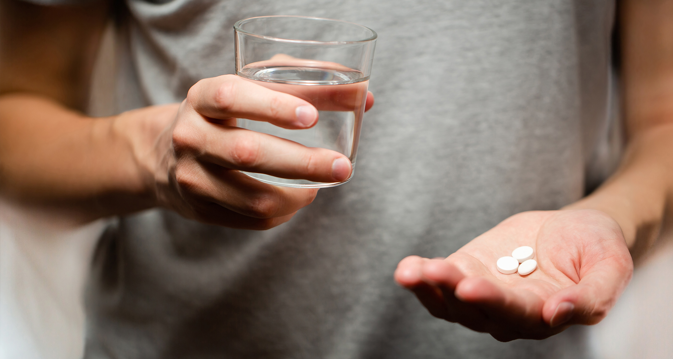 Close up of the one round white pill in male hand