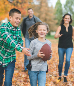 Family fall football in the leaves 
