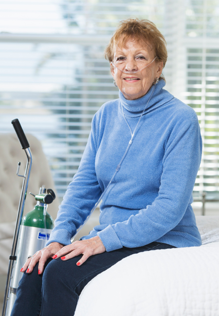 senior woman at home with portable oxygen tank