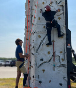 Two disabled veterans scaling climbing wall