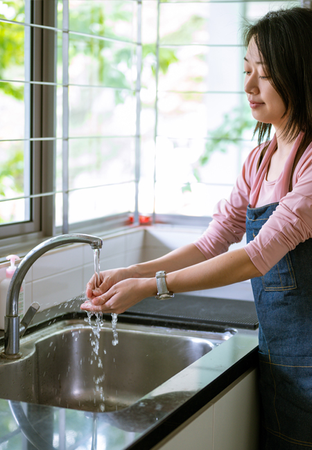 Woman washing hands in kitchen