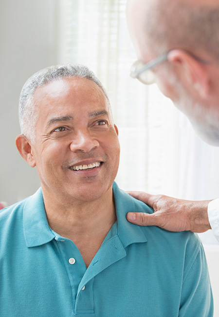 Male doctor talking with mature man