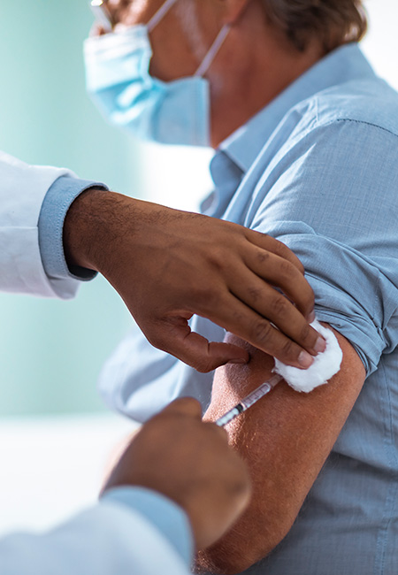 Man receiving a vaccine from his doctor
