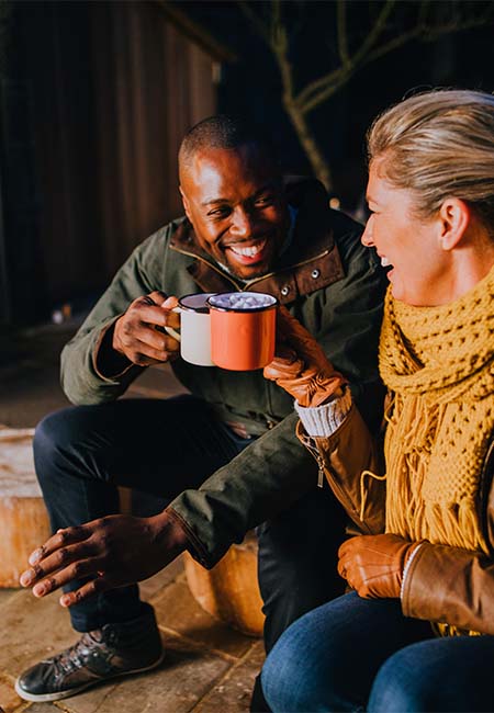 Friends having hot chocolate by the fire.