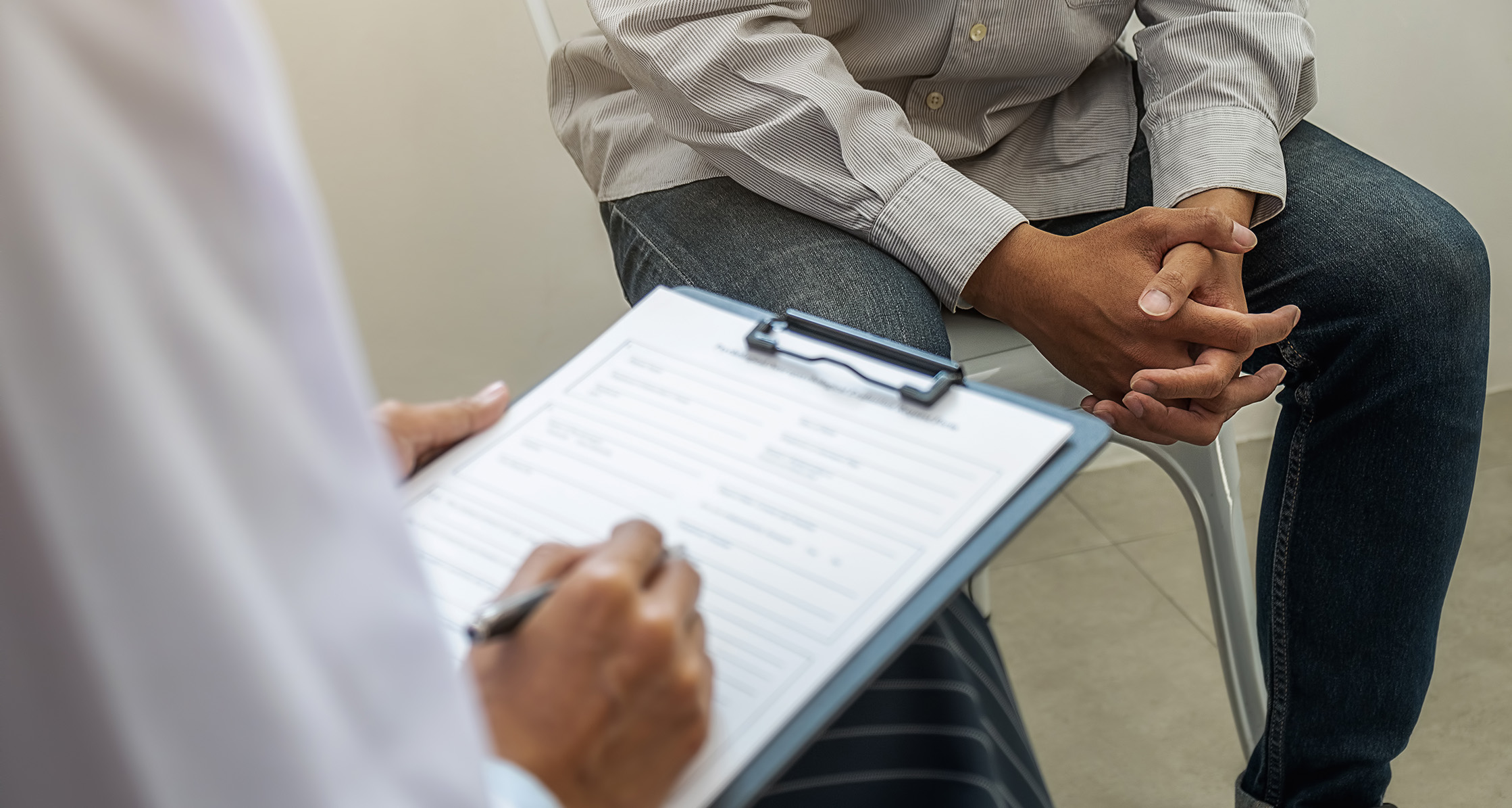 Therapist filling out form while talking to patient