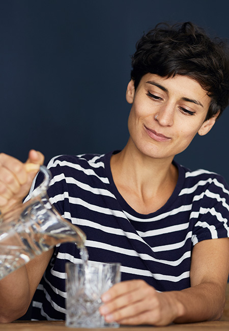 Woman at home pouring water.
