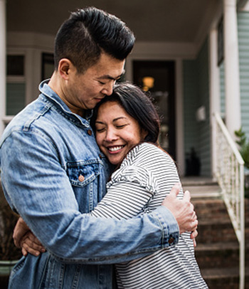 Young couple in front of home.