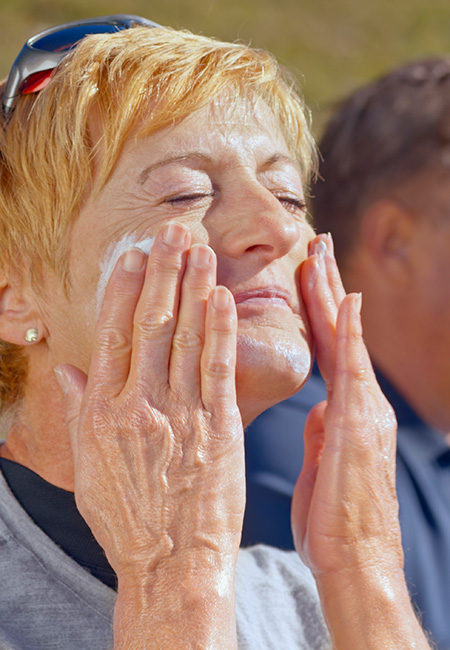 Woman applying sunscreen.