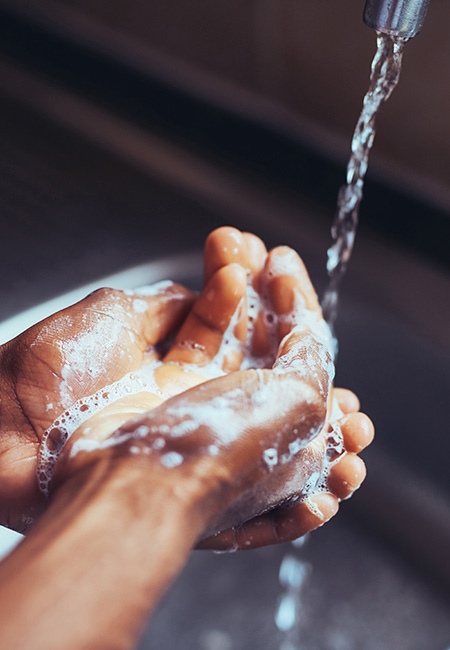 Man washing hands to minimize germs.