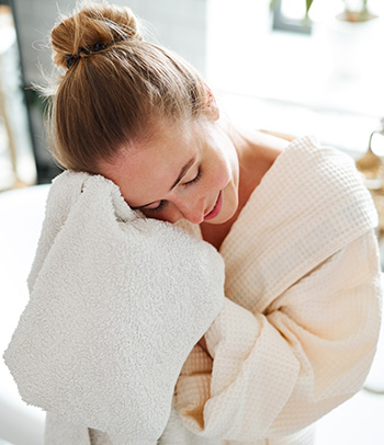 Woman wipes face with a towel after taking a bath.