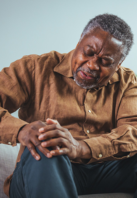 Senior man massaging his painful knee.