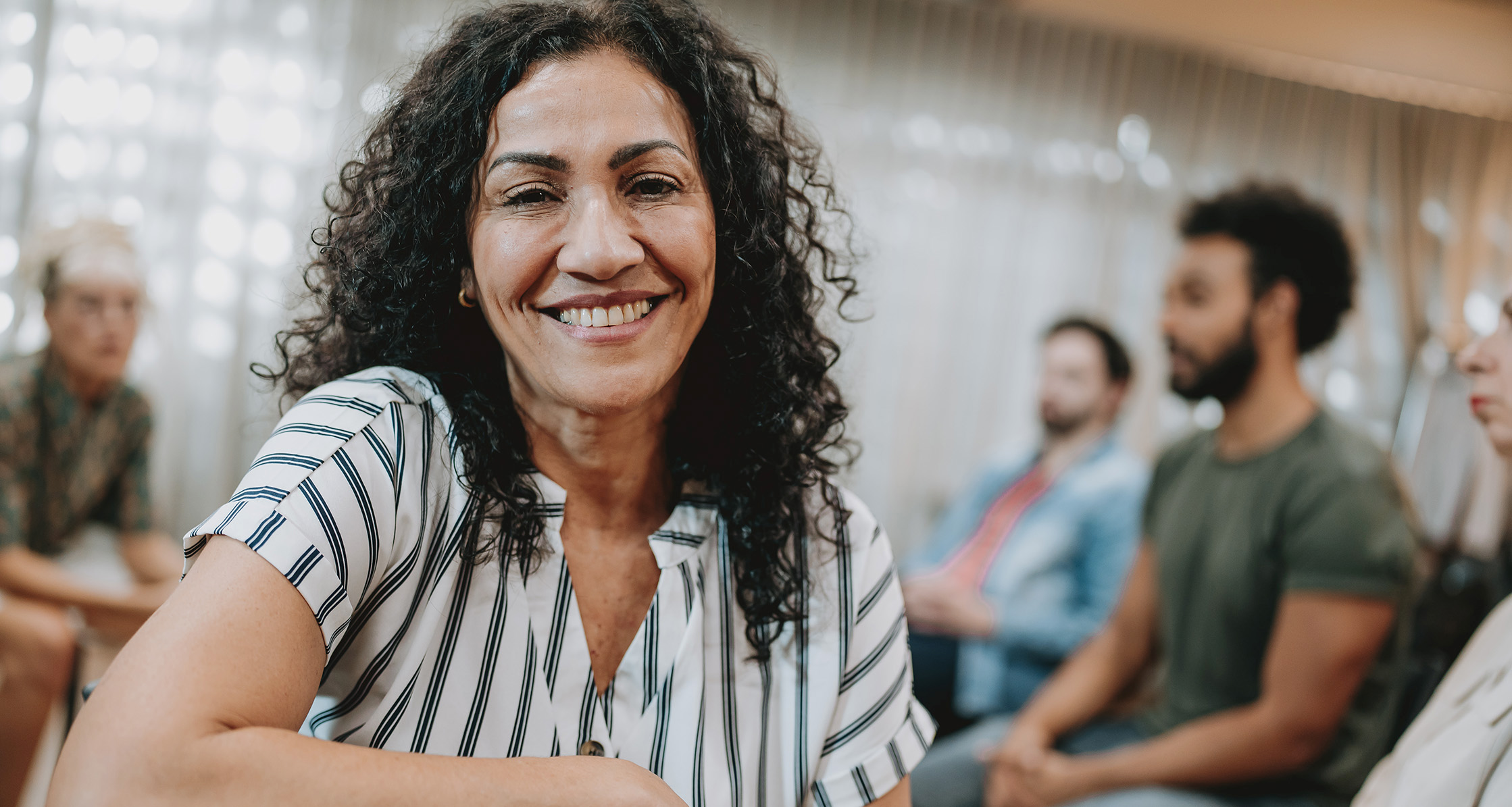 Woman smiling in mental health group therapy.