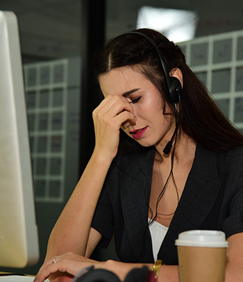 Woman working as an operator of a call center feeling stressed.