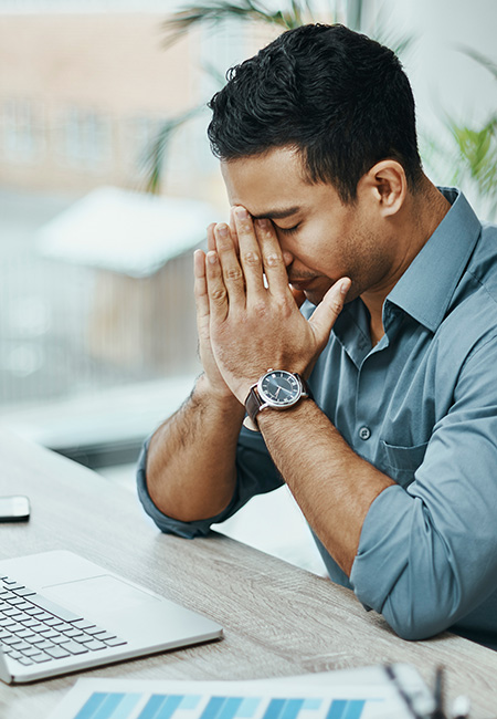 Young businessman looking stressed at work.