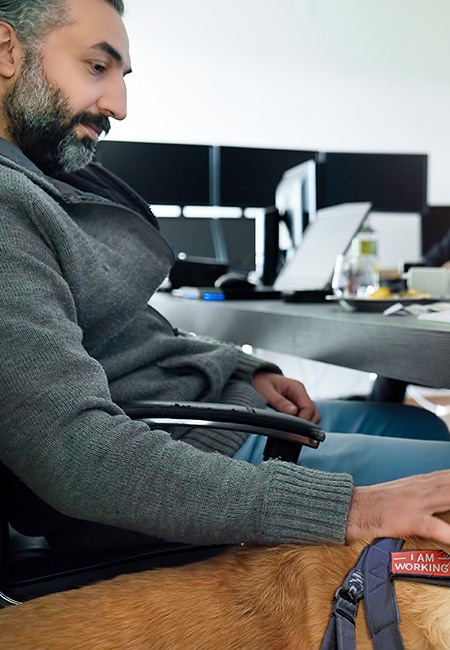 Man working at office with golden retriever service dog.