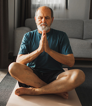 Senior man meditating at home