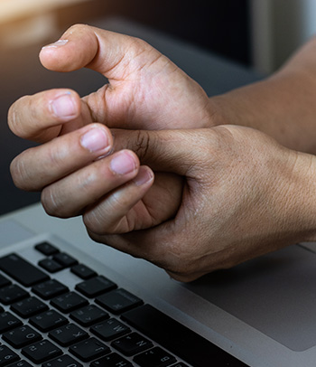 A man’s wrist and hand pain using a laptop working.