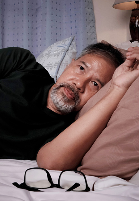 Man lying in bed from insomnia.