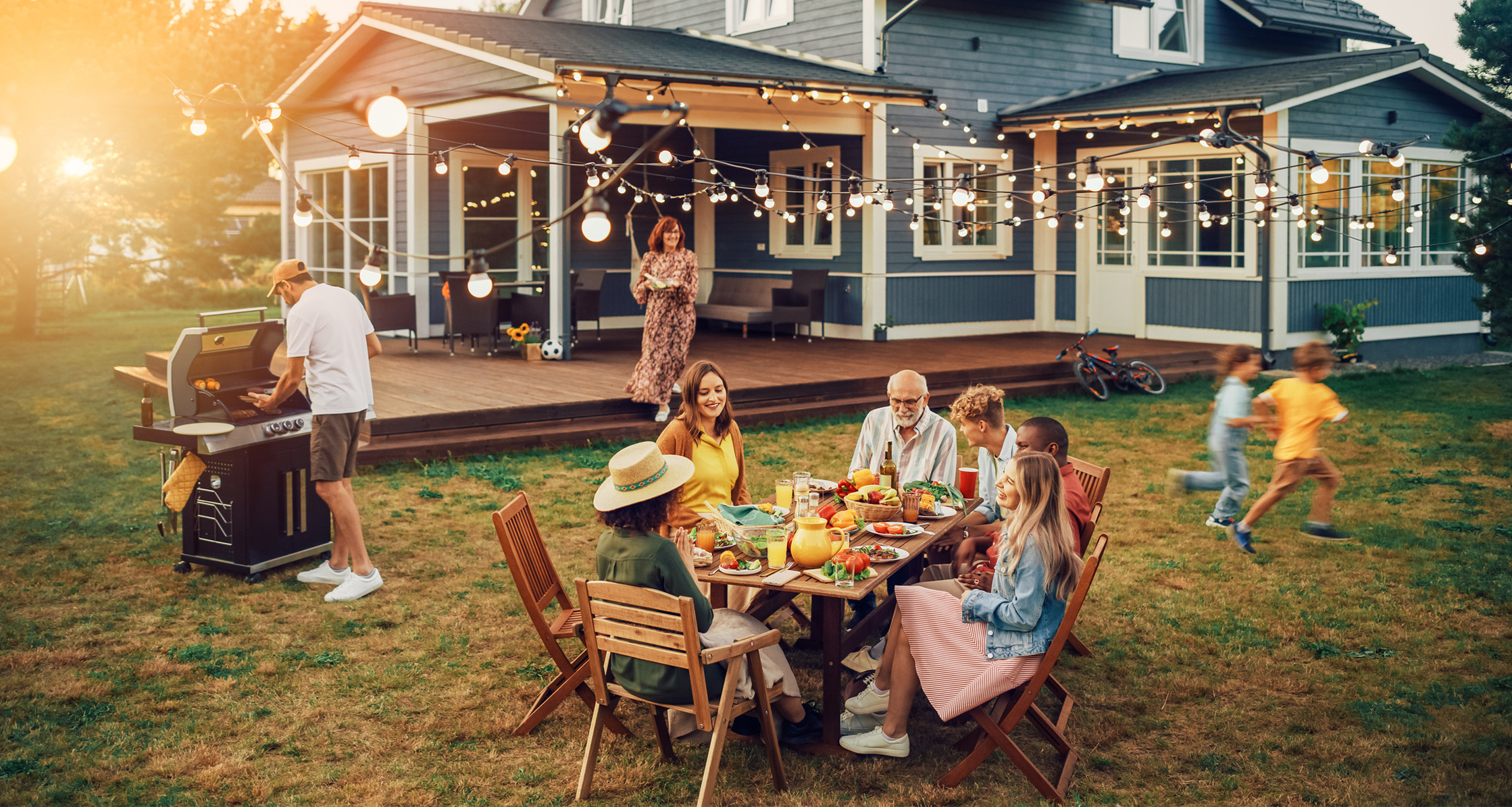 A family is getting ready to have dinner outside during the summer.