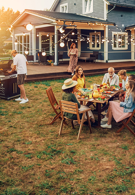 A family is getting ready to have dinner outside during the summer.