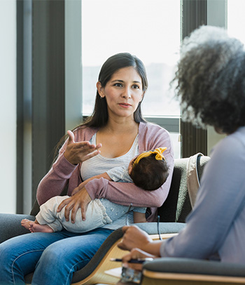 Woman sharing postpartum struggles with therapist.