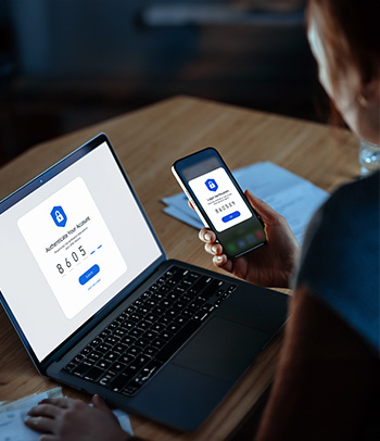 Young woman using a mobile device with Two-Factor Authentication security while logging in securely to her laptop.