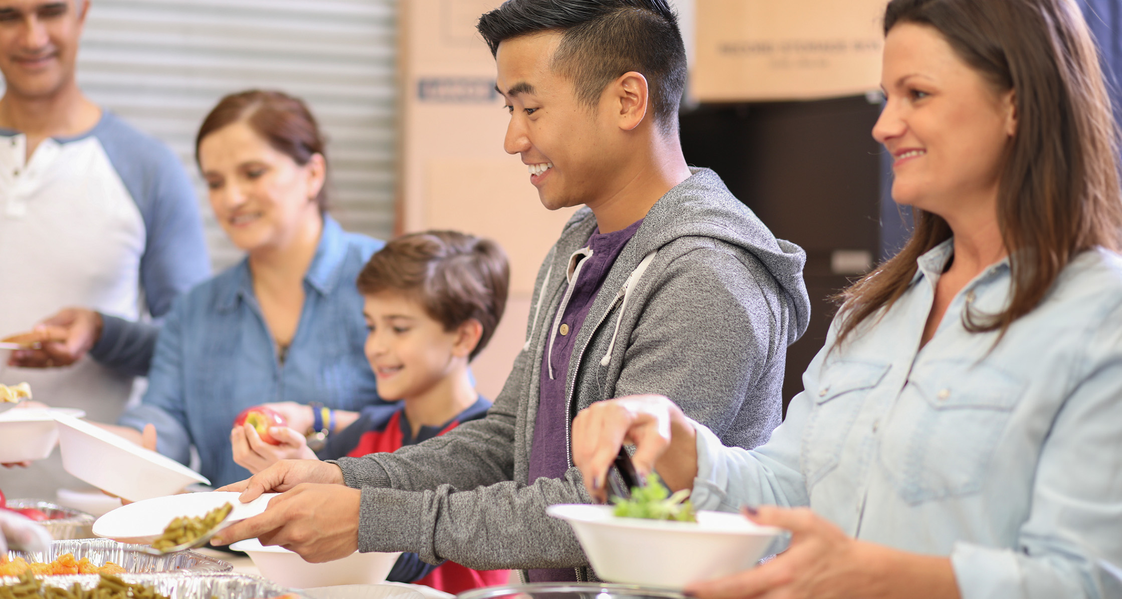 A young couple enjoys a hot meal together at a soup kitchen.