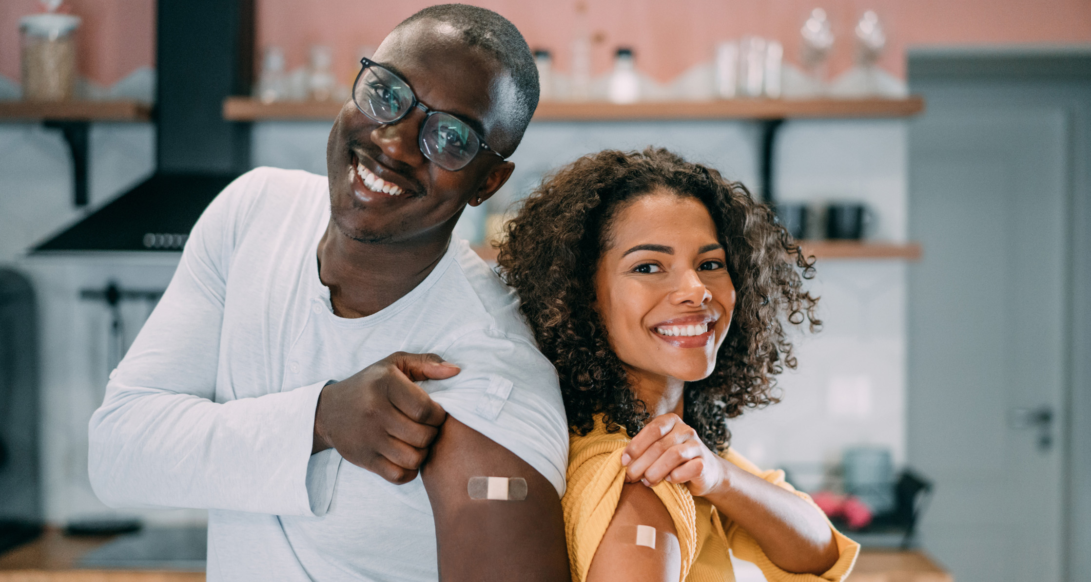 A young military couple proudly displaying their arms after receiving their vaccinations.