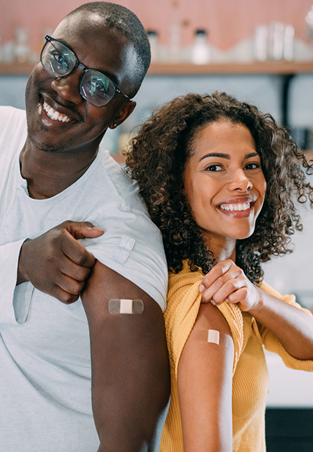 A young military couple proudly displaying their arms after receiving their vaccinations.