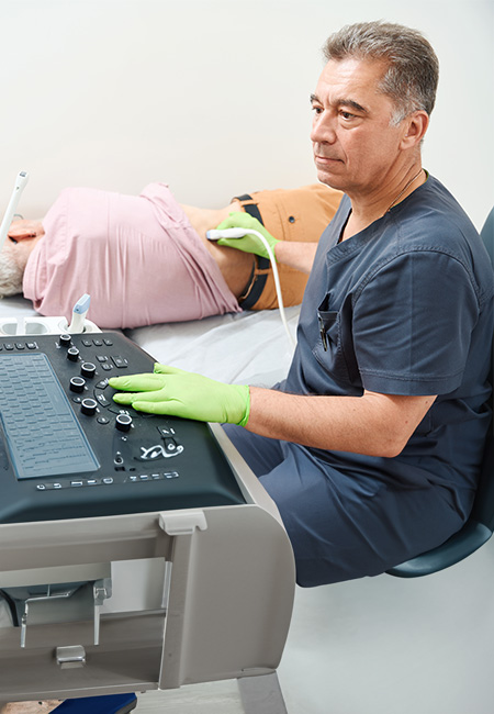 A male patient is undergoing an ultrasound exam of his kidneys.