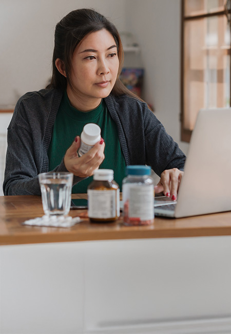 A person is researching information about her medication using her laptop.