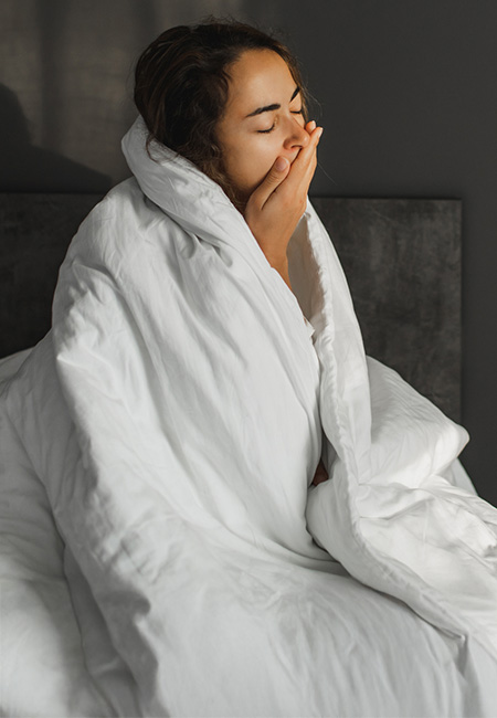 A woman who is yawning struggles to wake up in the morning.