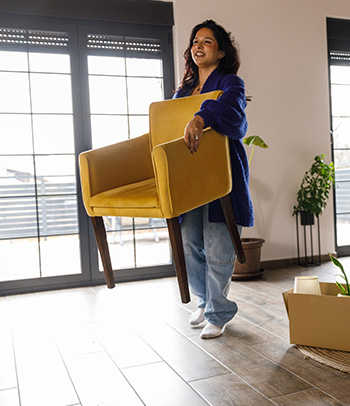 A person lifts a chair easily, regaining strength from physical therapy after a back injury.