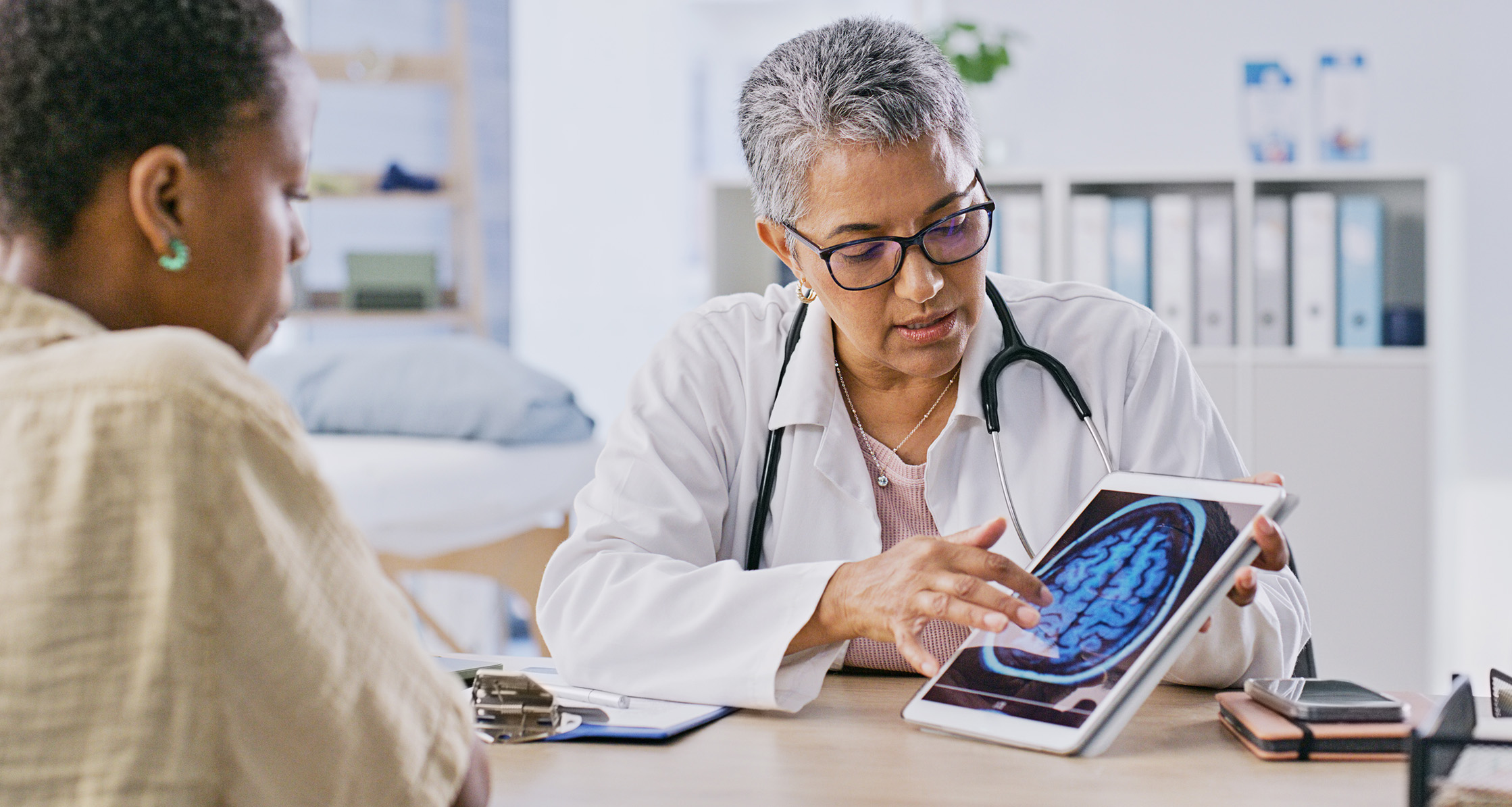 A doctor discusses brain health with a patient, using a digital scan to explain cognitive wellness.