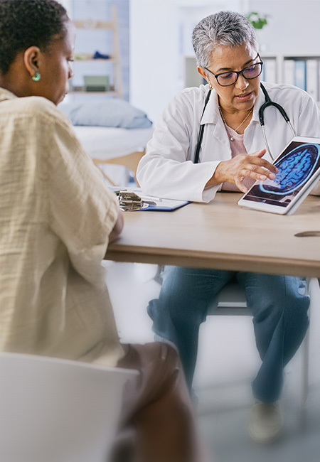 A doctor discusses brain health with a patient, using a digital scan to explain cognitive wellness.