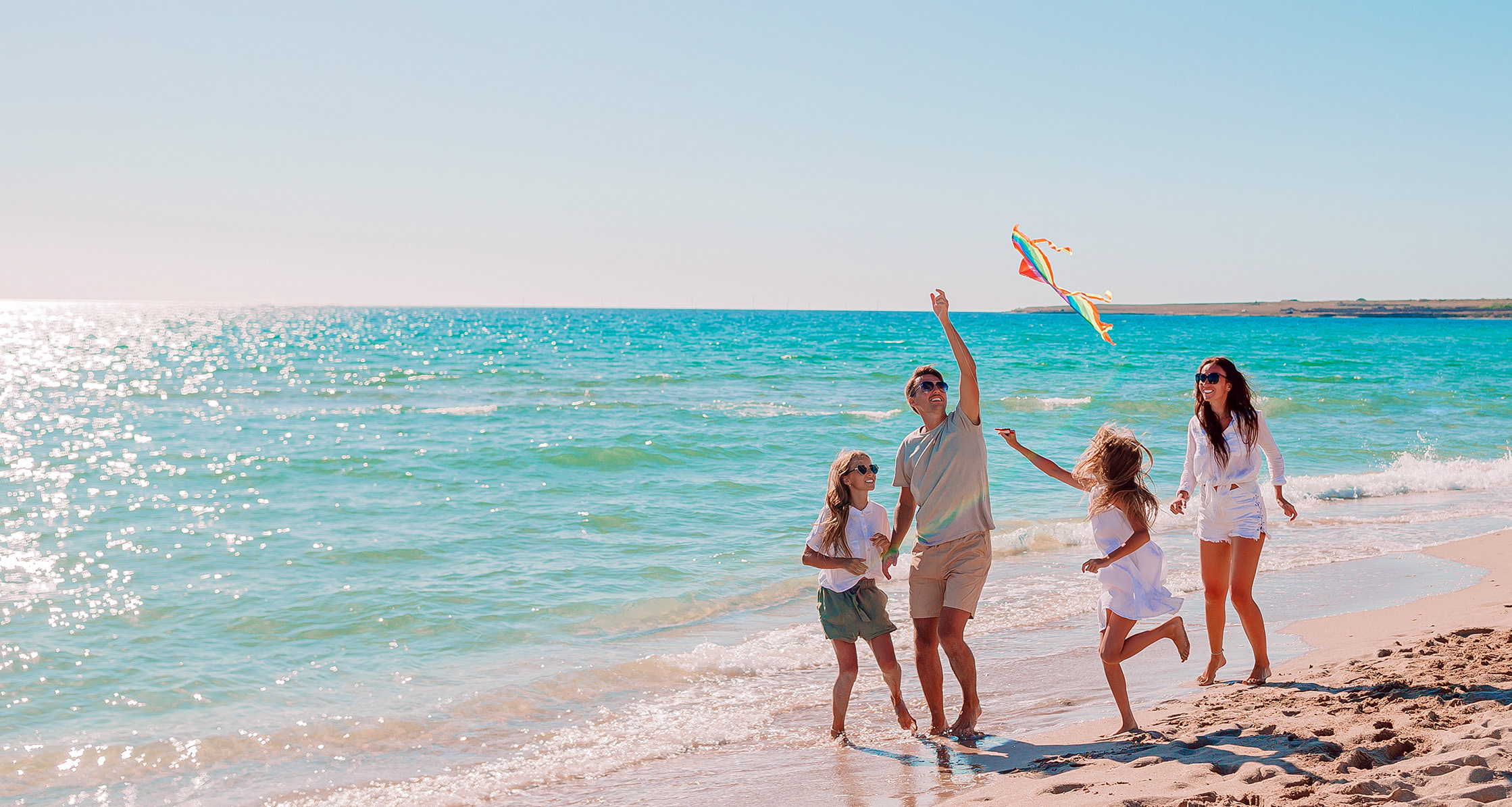 A family is flying a kite at the beach.