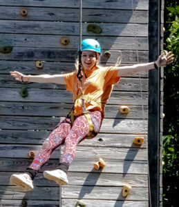A military dependent participates in a climbing wall activity to foster leadership skills at the youth summit.