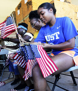 Military teens collect, fold, and store American flags intended for a military cemetery during the Military Youth of the Year Summit.